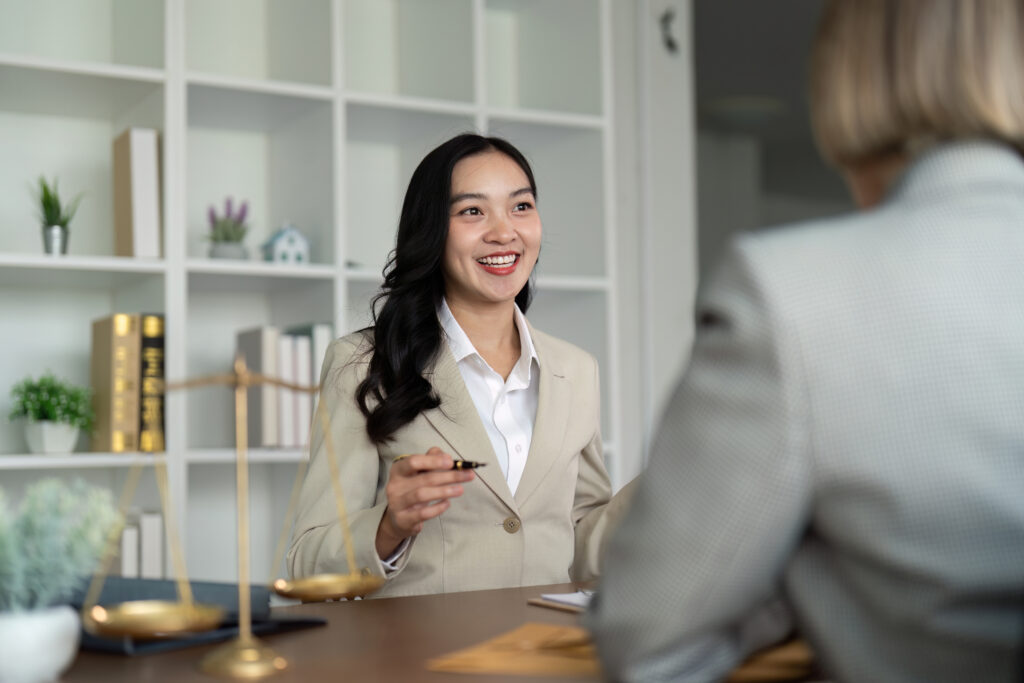Two businesswomen discussing contract papers sitting at the table.